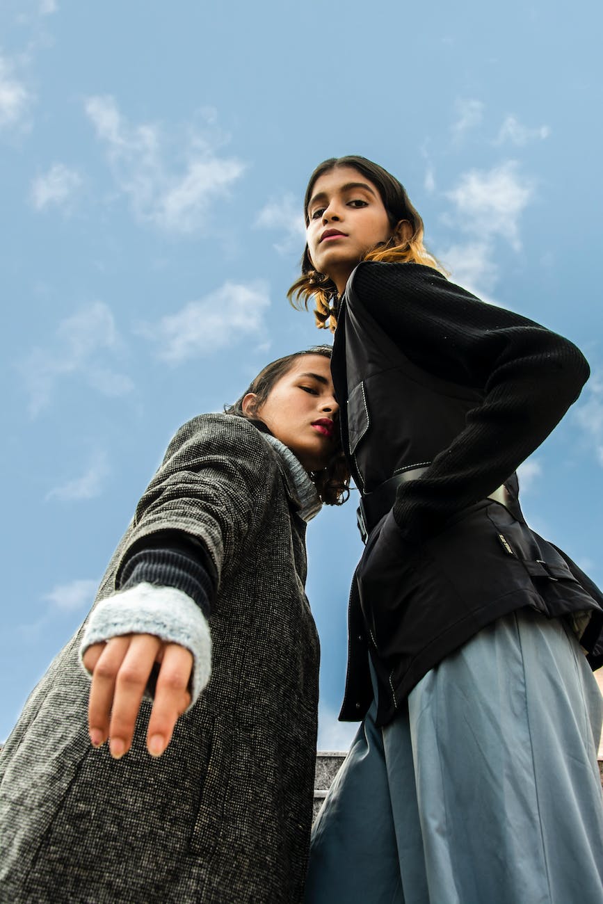 low angle photography of two women standing under white and blue sky